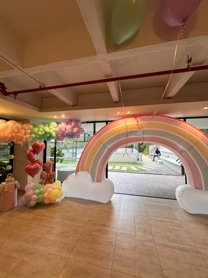 Arco arcoíris pastel en un salón de fiestas